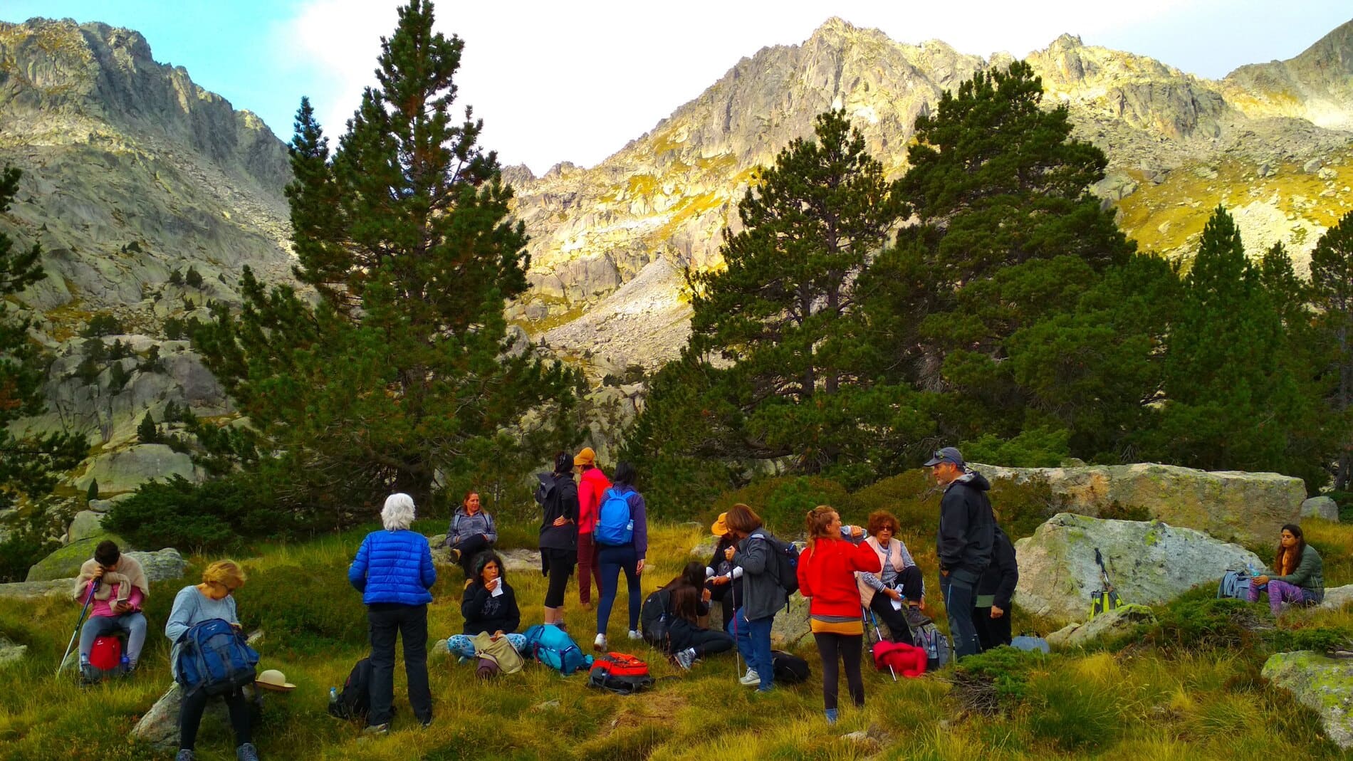Grupo de mujeres desayunando con un paisaje de alta montaña en primavera