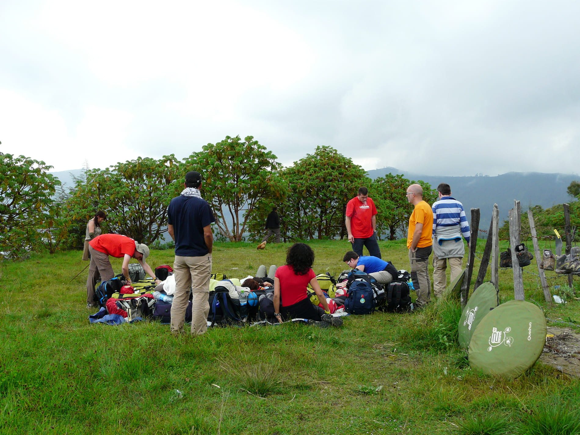 Grupo de gente preparándose para montar las tiendas en un prado en el macizo de l’Orri